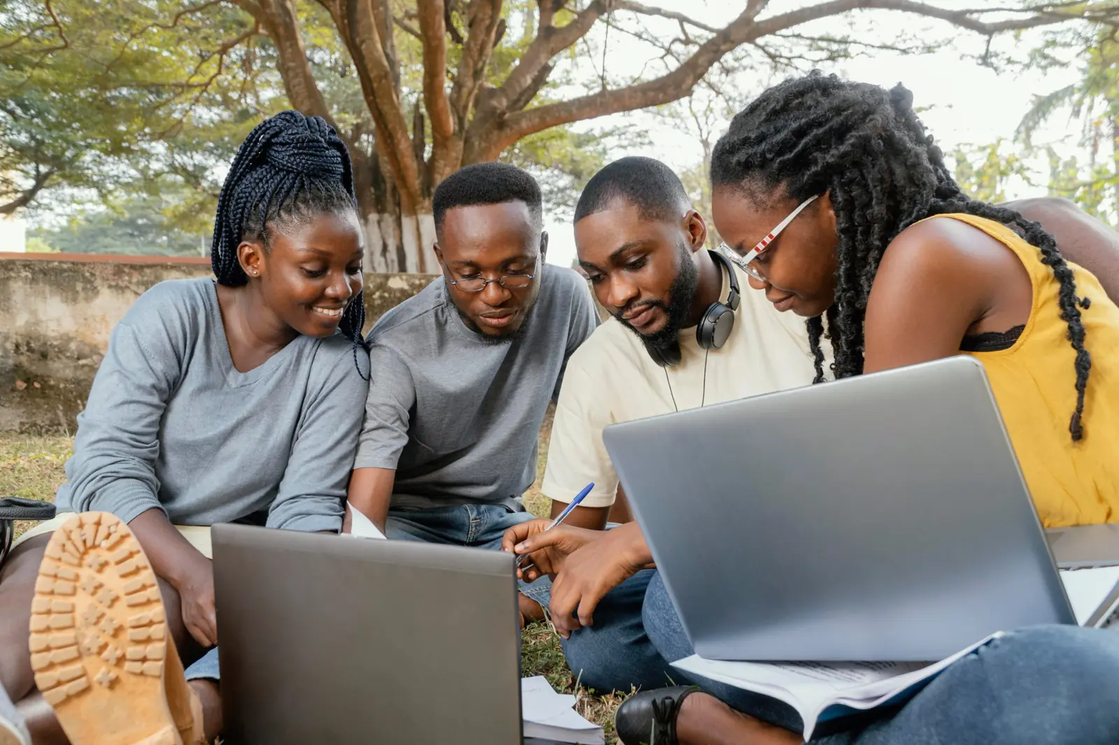 Students learning together with laptops outdoors